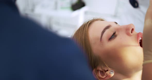 the Dentist Performs an Examination Using a Dental Mirror a Woman alt
