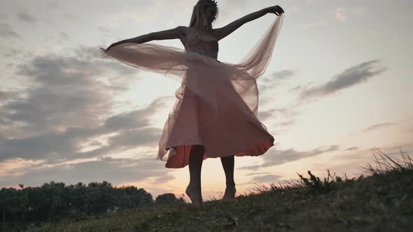 The Girl in the Dress Swirls Magically at Sunset alt