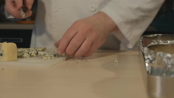 A Male Pastry Chef Slices Green Cheese and Places It on Top of His Signature Cheese Pie