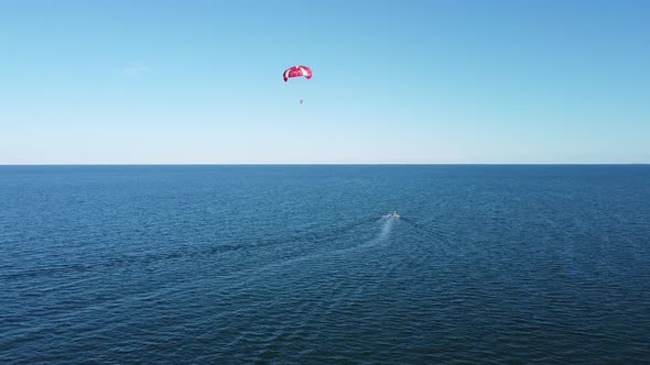 Extreme entertainment at the beach resort, parachuting by boat, blue sea, vacation at sea. alt