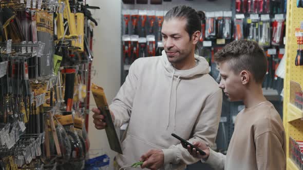 Child and Father Choosing Products at Hardware Store alt