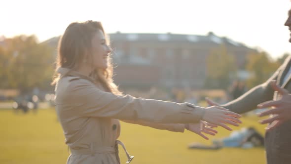 Side View of Senior Man and Adult Daughter Meeting in Park and Hugging alt