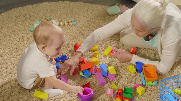 Loving Grandma and Baby Grandson Playing with Toys 