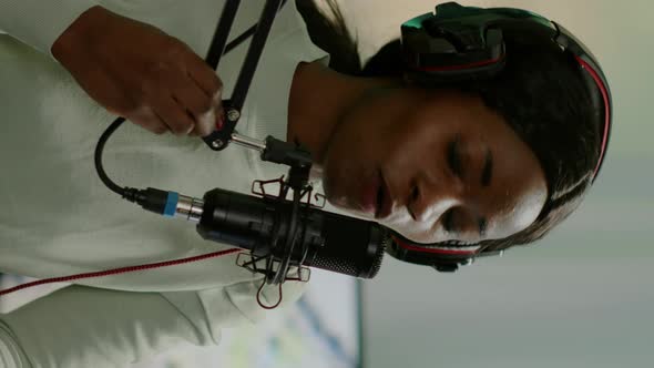 Vertical Video African Woman Host of Online Show Talking Into Microphone alt