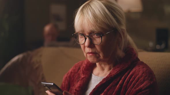 Elderly Woman Reading Shocking News on Smartphone alt