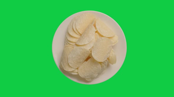 Potato chips in white plate rotation on chroma key green screen background. Alpha Channel.