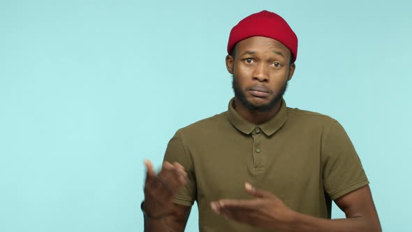 Slow Motion of Handsome Black Man with Beard Wearing Red Beanie Raising Eyebrows and Demonstrate