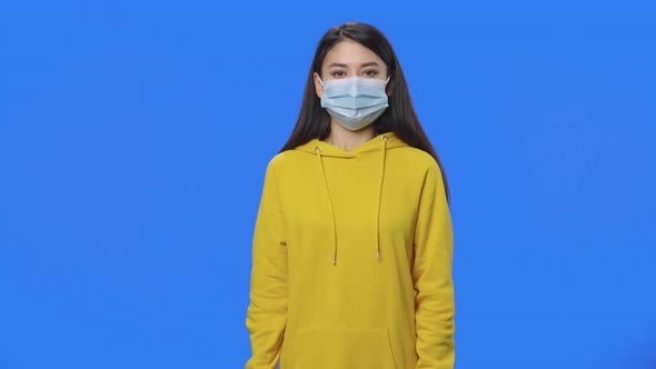 Portrait of Pretty Brunette in Medical Mask Talks and Sighs Heavily alt