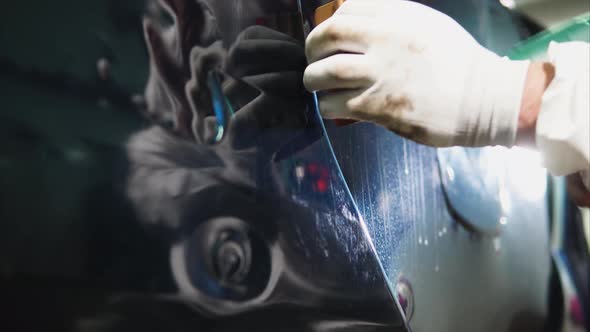 Close Up Shot of Man Applying Vinyl Film While Tuning Car