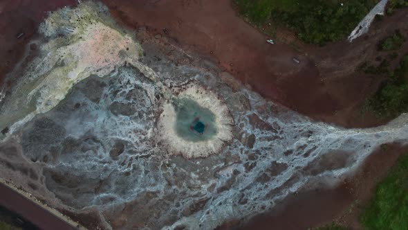 Drone Flight Over Geyser Pool And Surrounding Geothermal Landscape alt