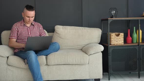 Handsome Man Is Typing Text on Gray Laptop