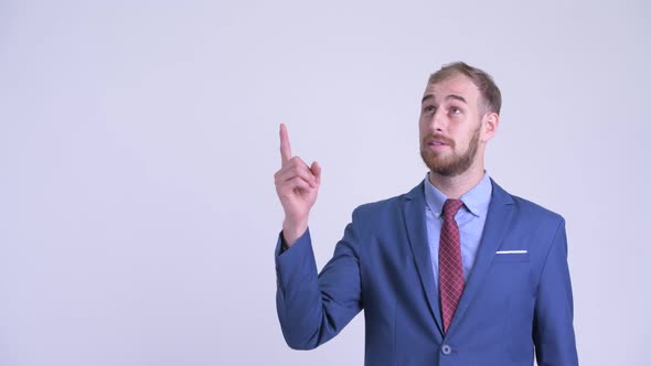 Happy Bearded Businessman Talking and Pointing Up