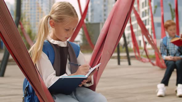 Blonde Schoolgirl Doing Homework Outdoors alt