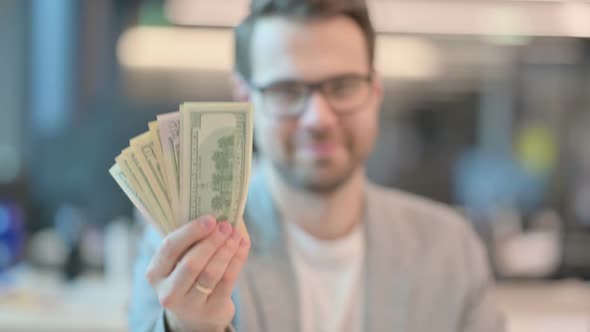 Portrait of Confident Casual Man Holding Dollars alt
