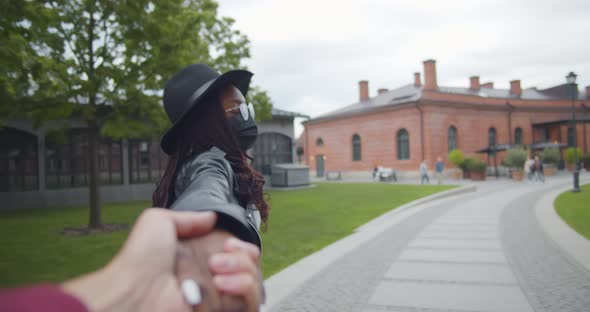 African Tourist Woman in Safety Mask Leading Man alt