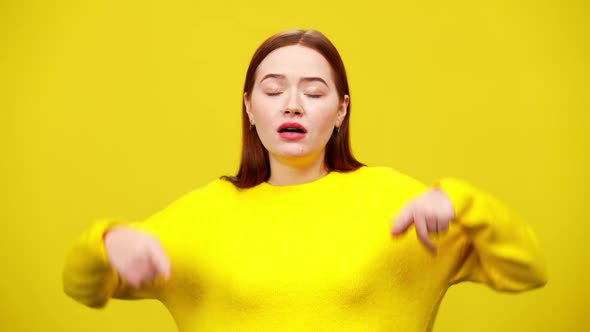 Stressed Young Redhead Woman Sighing and Closing Ears with Hands at Yellow Background alt