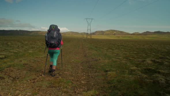 dramatic iceland landscape, hiker woman hiking on trail, camera following movmement on steadicam
