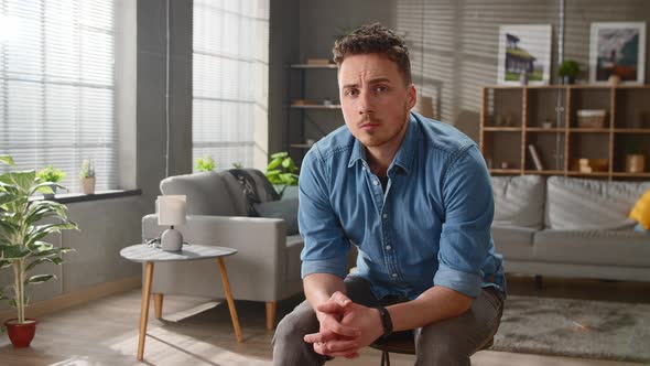 Portrait of a Young Handsome Cute Man Sitting Alone in the Living Room Room Early in the Morning  alt
