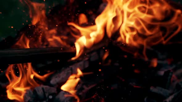 Burning Log Fire Flames in the grill. Beautiful fire burns brightly. Embers of the fire climb up.  alt