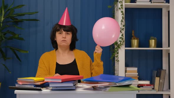Upset Middle Aged Woman Looking at Camera and Holding Balloons Celebrating Birthday Alone