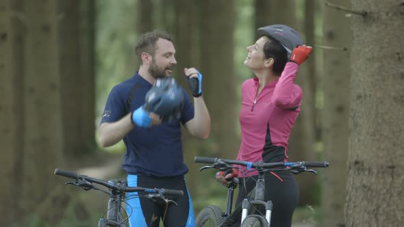 Couple cycling through forest Tracking Left and resting