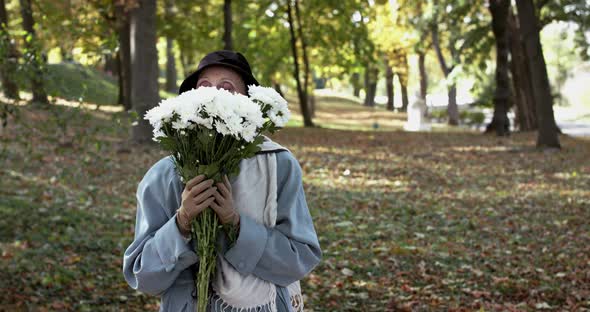 Elegant Lady in Hat Enjoying From Bouquet's Smell Looking and Smiling at Camera alt