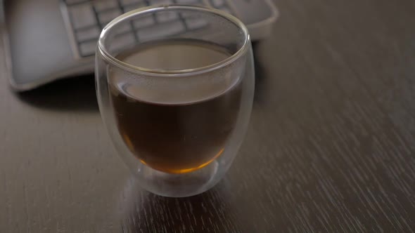 Work place with glass of tea and wireless keyboards 1080p FullHD panning  footage - Tea time after f