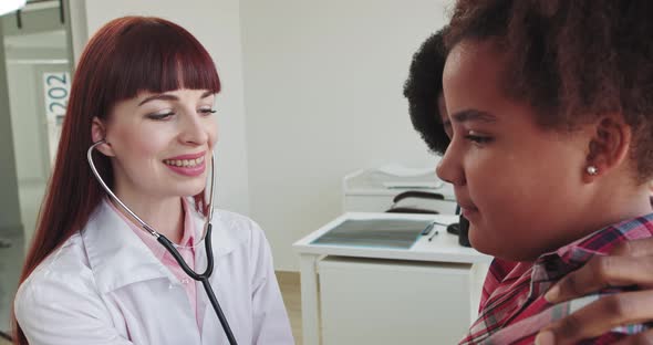 Female Doctor Pediatrician Using Stethoscope Listen To the Heart of Kid Girl at alt