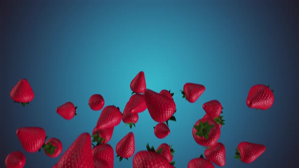 THE MOVEMENT of fresh strawberries falling on a blue background.