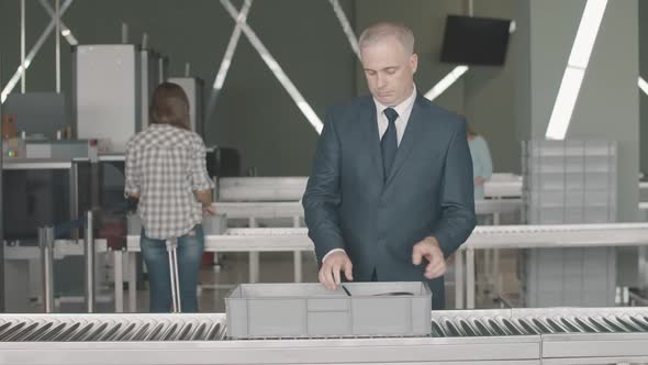 Portrait of Confident Mid-adult Caucasian Businessman Passing Security Check in Airport. Man in alt