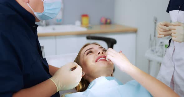 Beautiful Positive Female Patient Shows Teeth to the Dentist After Treatment alt