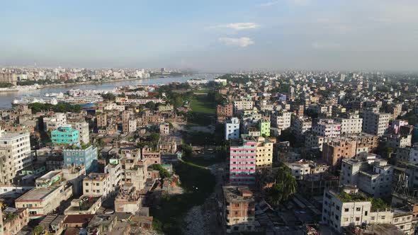 Aerial across urban Dhaka city showing dry canal used as industrial garbage dump alt