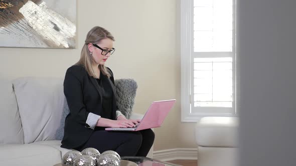Revealing A Young Female Business Entrepreneur Typing On Her Laptop Computer In A Living Room 1