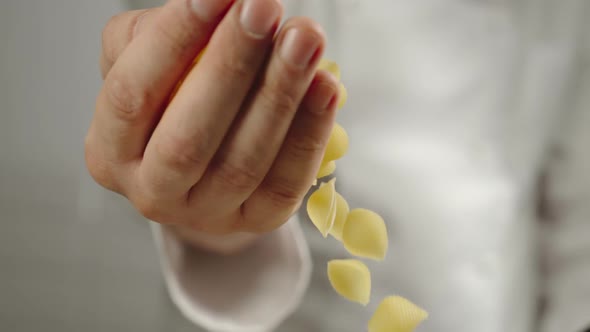 Chef Pours Conchiglie Pasta While Cooking 