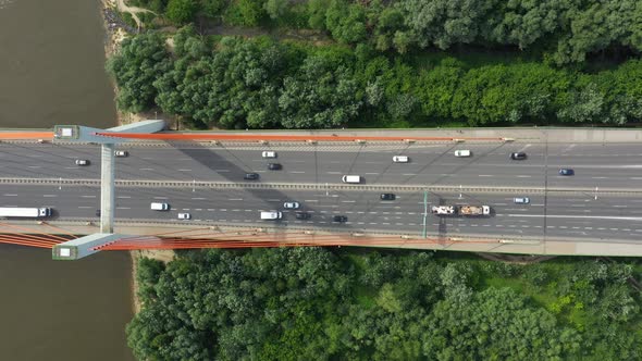City caring at highway bridge on background smooth river surface drone view alt