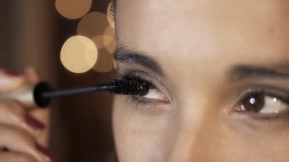Woman applying eyelash mascara un slow motion