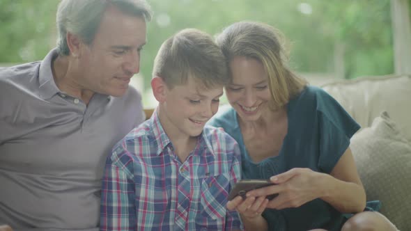 Family looking at smartphone together alt