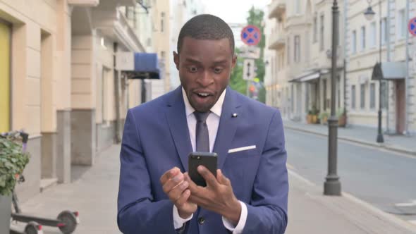 Walking African Businessman Cheering for Online Success alt