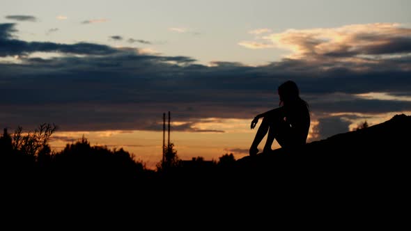 Silhouette of a Girl on the Sunset Background alt