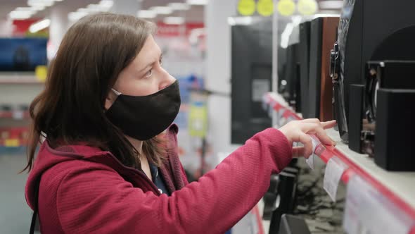 Girl in a Gadget and Device Store Chooses a New Audio System