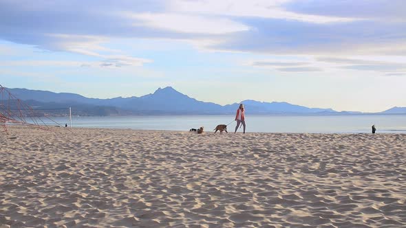 Woman Walking Along the Beach with Her Dog