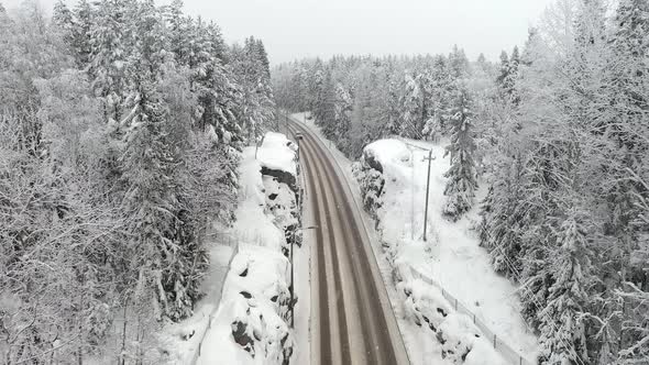 Idyllic Drone Shot of Snow Falling Onto a Road in Finland alt