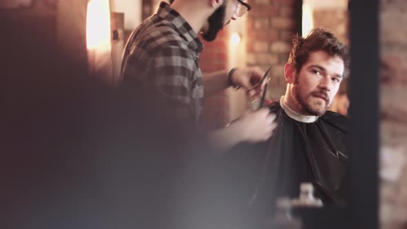 Young Adult Male having haircut in barbershop