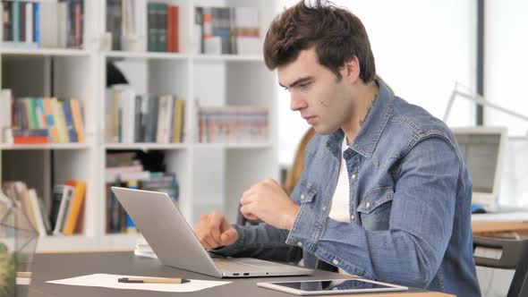 Excited Creative Man Celebrating Success at Work alt