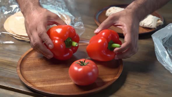 Hands Beautifully Spread Tomatoes and Sweet Pepper on Wooden Round Cutting Board alt
