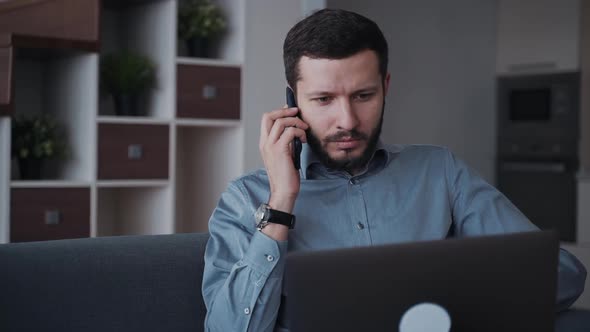 Man Using Laptop Computer and Cellular Working at Home alt