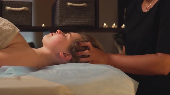 A Woman Enjoys a Head Massage at a Massage Spa