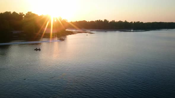 Beautiful Sunset Beams Reflecting in River Water, People Enjoying Relax on Boats alt