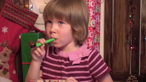 Little Blond Girl in Blowing Ribbon While Standing Isolated Over Wooden Background alt