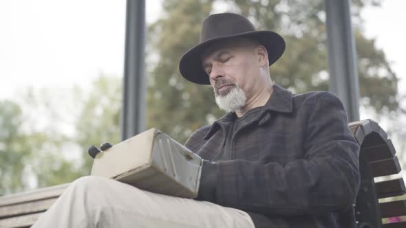 Bottom Angle View of Serious Concentrated Detective or Spy Opening Box with Novichok Poison and alt